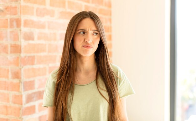 woman feeling sad, upset or angry and woman looking to the side with a negative attitude, frowning in disagreement