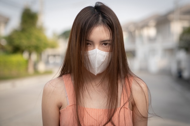 Woman feeling sick. She wearing protective mask. Feeling bad with air pollution.