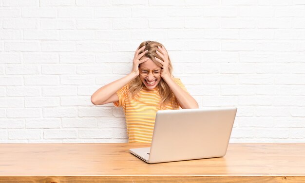 woman feeling stressed and frustrated, raising hands to head, feeling tired, unhappy and with migraine