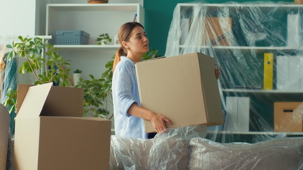 Woman feels sudden back pain when trying to lift a carton box