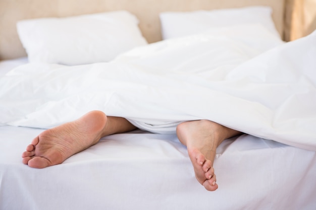 Woman feet under a duvet