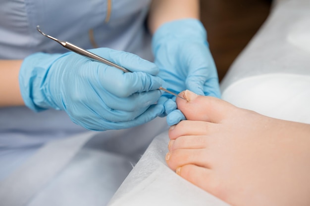 Photo woman feet receiving pedicure in beauty clinic