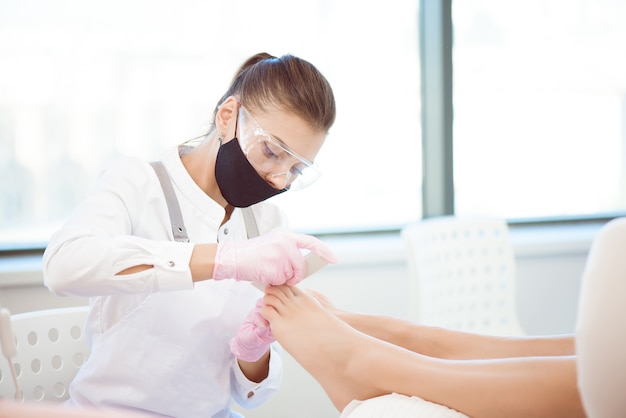 Woman feet receiving pedicure. Close up concept.