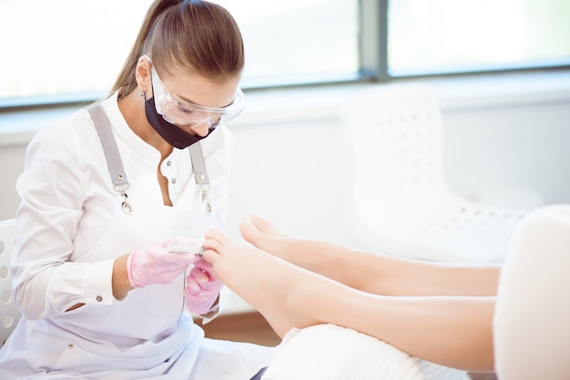 Woman feet receiving pedicure.