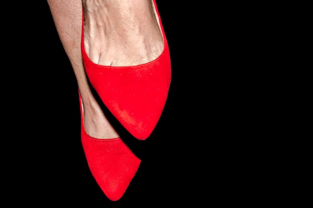 Woman feet with red shoes on white background.