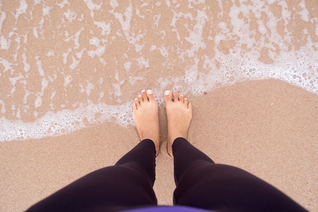 Photo woman feets standing on the beach