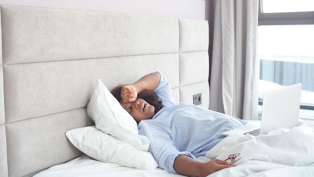 Woman fell asleep watching online movies on a laptop in bed