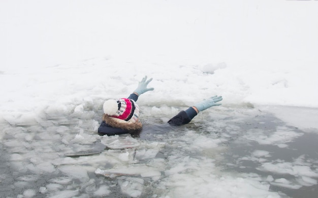 Foto la donna è caduta attraverso il ghiaccio affogando nell'acqua gelida giornata invernale