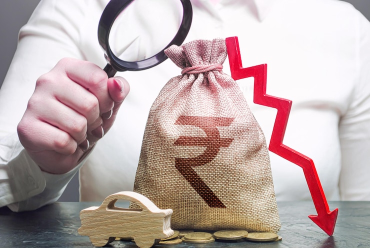 फोटो महिला महिला प्रबंधक लाल नीचे तीर और ऑटोमोबाइल के साथ एक भारतीय रुपये के पैसे के बैग की जांच करती है इलेक्ट्रिक वाहन समर्थन सब्सिडी कार बीमा कर रखरखाव ईंधन उत्पाद शुल्क