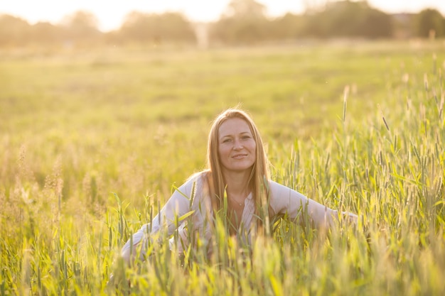 Woman in the field enjoys the wheat harmony with nature