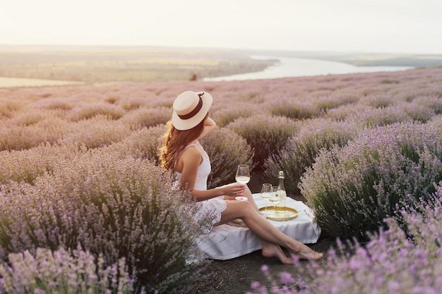 Woman in a field of lavender with a glass of wine