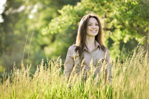 a woman in a field of tall grass with a smile on her face