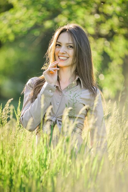 a woman in a field of tall grass with a smile on her face