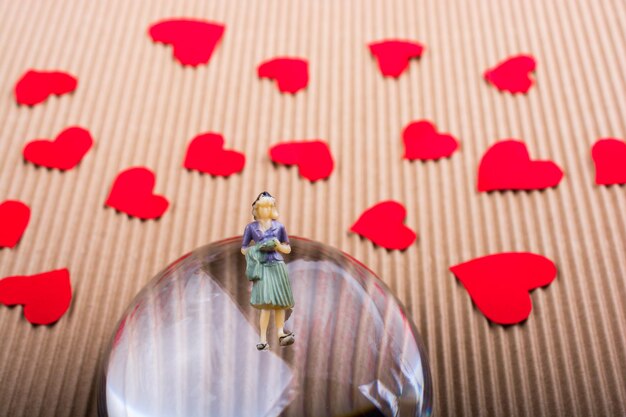 Foto figurina di donna e concetto di amore con cuori di carta rossa