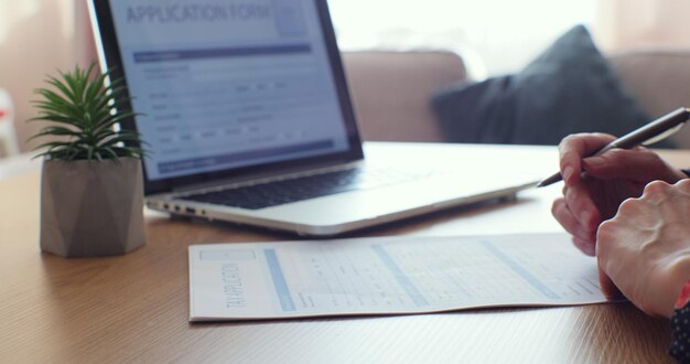 Woman filling tax form writing on document Paperwork in office Close up