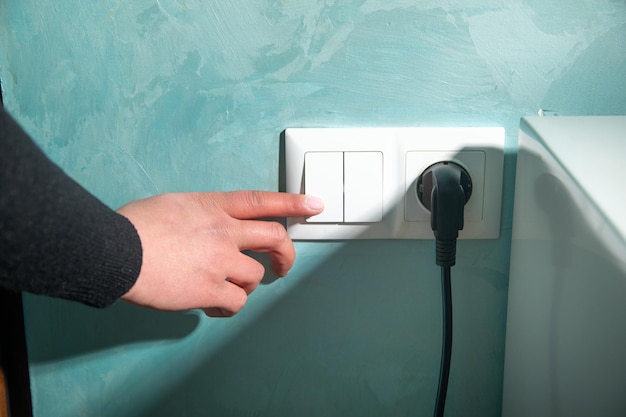 Woman finger pushing light switch turn on or off