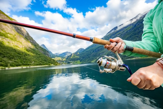 Woman fishing on Fishing rod spinning in Norway