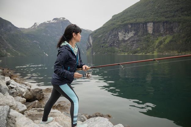 Woman fishing on Fishing rod spinning in Norway