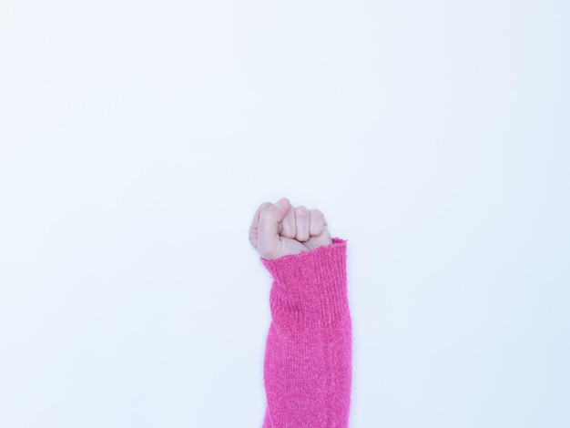 Foto pugno di donna su sfondo bianco.