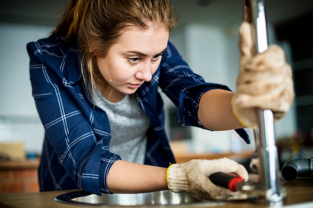 Woman fixing kitchen sink