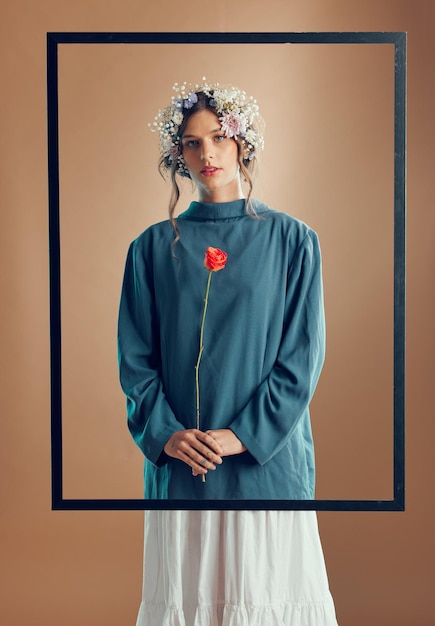 Woman floral crown and studio with frame rose or beauty for fashion in portrait by background Model girl and flowers in spring clothes or design with red rose plant in hands by studio background