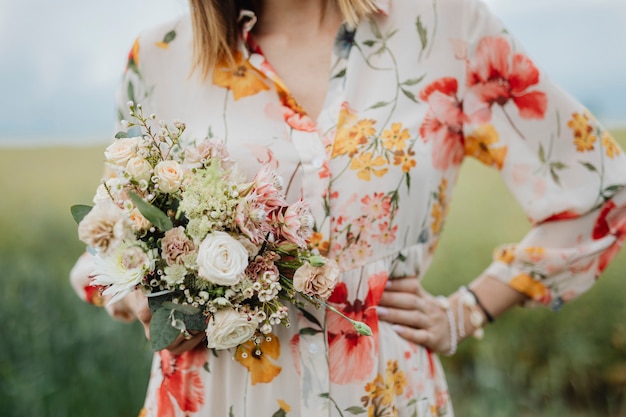 Woman in a floral dress holding a flower bouquet