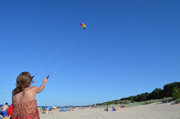 Woman flying kite on the beach