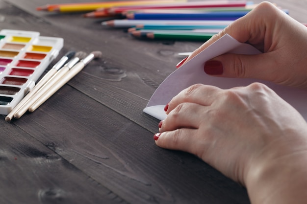 Woman fold sheet of paper while do origami