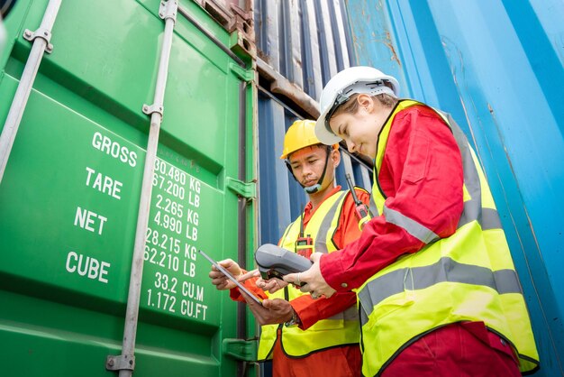 Woman foreman and operator using credit card swipe machine for\
checking code of cargo container before import exprot concept\
logistics transportation shipping lady foreman checking cargo\
warehouse