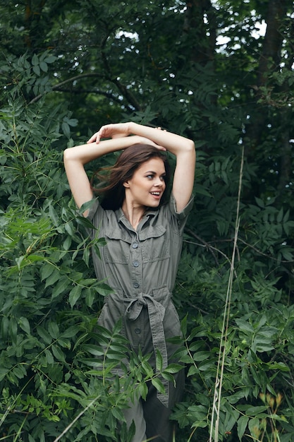 Woman in forest Holds his hands behind his head and looks away well nature travel