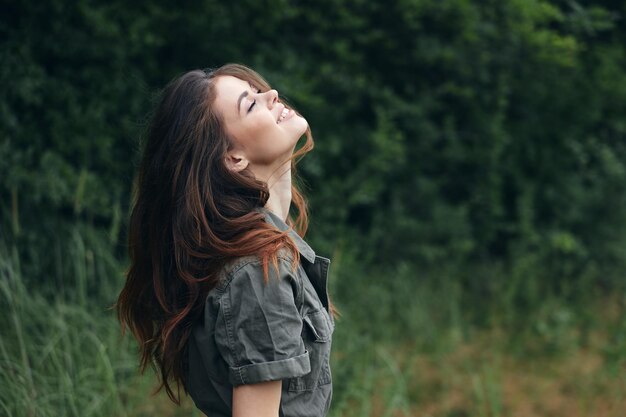 Woman in the forest looking up with closed eyes smile freedom fresh air background nature