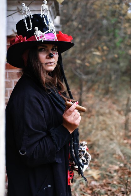 A woman in the form of Baron Saturday with a cigar in her hand