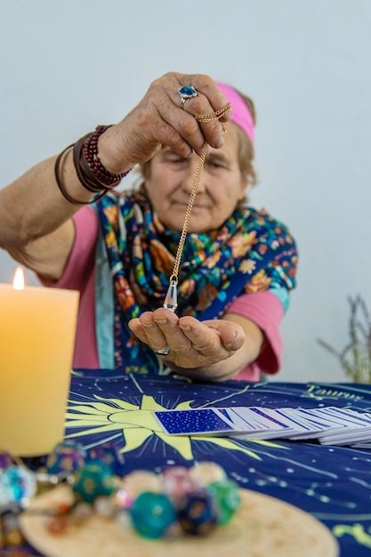 Woman fortune teller fortune telling pendulum Selective focus