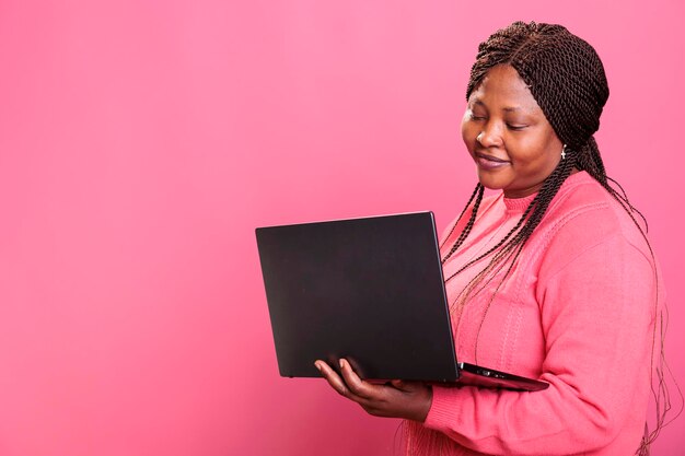 Woman freelancer holding laptop computer while navigating on social media and online website network person