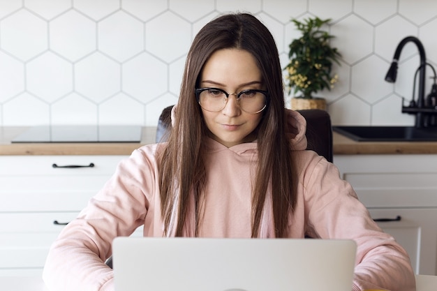 Photo woman freelancer with glasses concentrating working on laptop