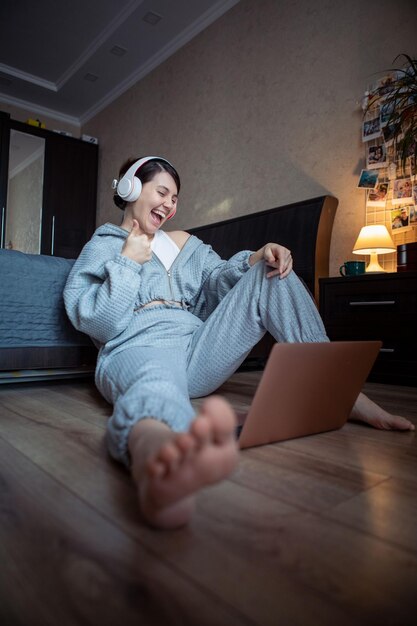 Woman freelancer working on laptop at home sitting on the floor