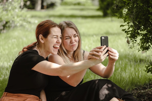 Woman friends having fun on picnic with cat talking happy