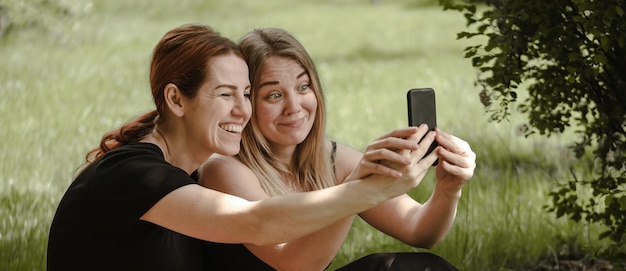 Photo woman friends having fun on picnic with cat talking happy