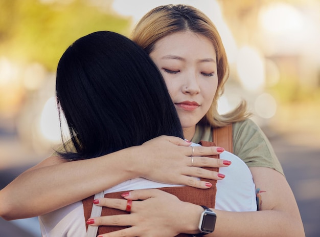 Woman friends and love hug in city outdoors together for sorry support and lesbian couple forgive in street Asian people friendship and emotional hugging for grief or sadness in urban city street