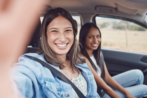 車の中で一緒にロードトリップのセルフィー旅行や休日の冒険のための女性の友人と肖像画 幸せな女性は、車の旅行輸送や休暇の休憩で写真の思い出やソーシャルメディアに微笑みます