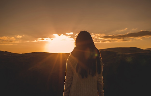 Woman from the back watching the sunset