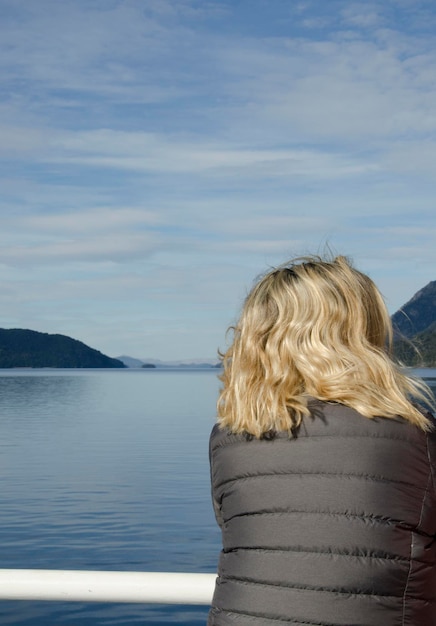 woman from behind on the railing of a boat