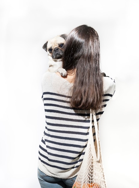 Woman from behind with pug dog going to do the shopping Shopping with dog