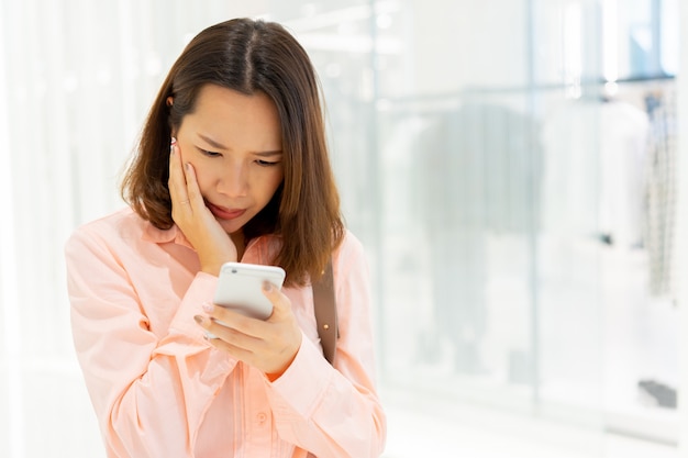 woman frown on face with serious feeling while read comment on social media for cyber bully concept