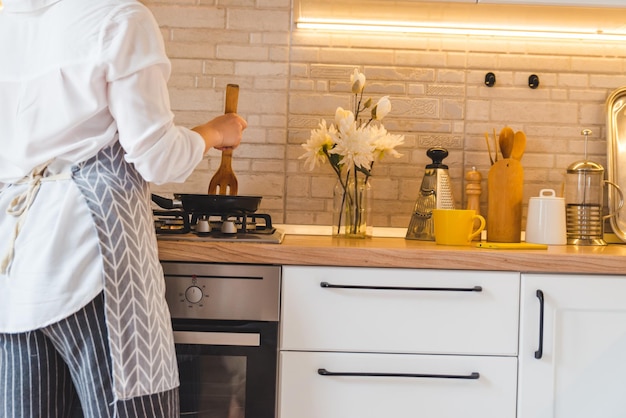 Woman fry on pan kitchen view