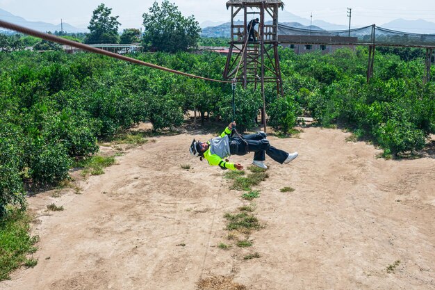 Женщина в полном экстремальном спорте под названием CANOPY ZIP LINE