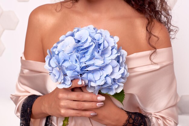 woman in gentle romantic robe holding hydrangea in her hands bode ans skin care and woman health