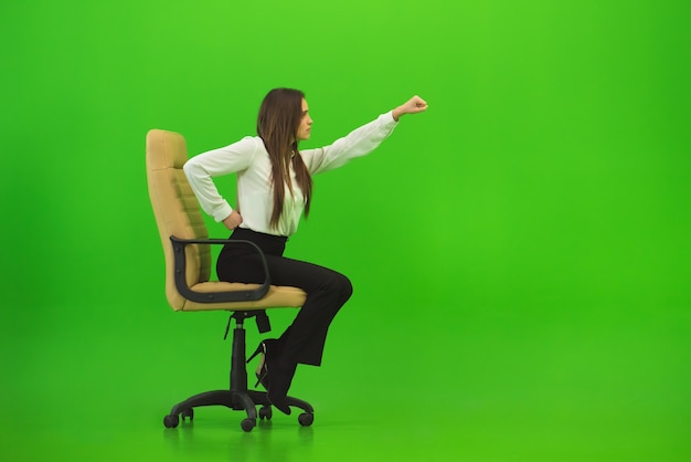 The woman gesture on the chair on the green background