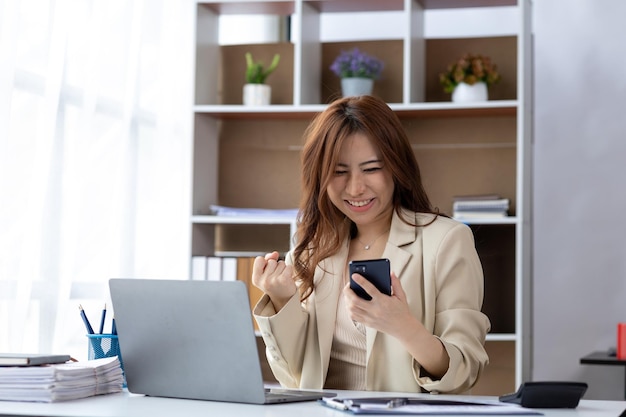 Woman gesturing and looking at the laptop businesswoman\
checking company monthly sales and pretending to be happy as sales\
meet planned targets according to policy sales management\
concept