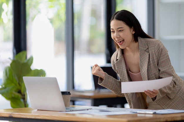 Woman gesturing and looks at laptop screen businesswoman checking company monthly sales and pretending to be happy as sales meet planned targets according to policy Sales management concept